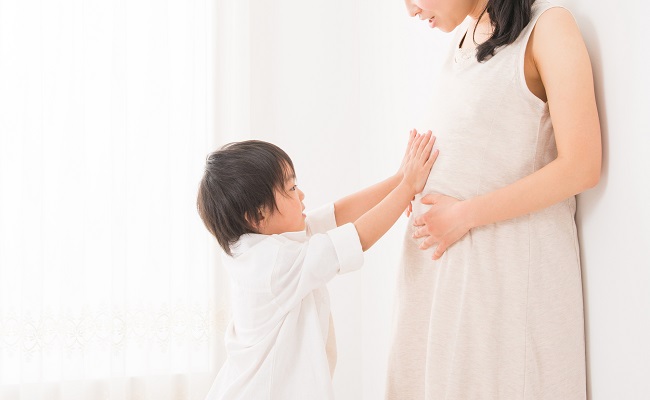 妊婦さんのお腹を触る男児