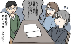 義父が「結婚式はビジネススーツで行く」と言い、テーブルを囲む家族の前で説明している。女性が「両家で服装の格がそろわなくなってしまう…」と戸惑った表情を見せ、隣の男性も困った様子で聞いている場面。